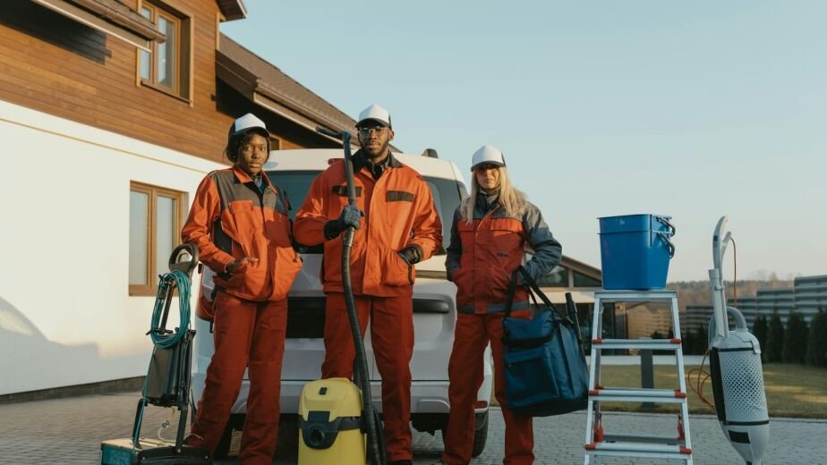 Group of workers in protective gear standing beside equipment outdoors.